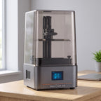 Aura One resin 3D printer on a light oak desk in a bright home office
