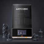 Aura Max Pro resin 3D printer with detailed gray resin prints: a dragon, a knight, a horse on wheels and a lantern
