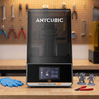 Aura Max Pro resin 3D printer on a workshop bench with nitrile gloves, flush cutters and resin miniatures