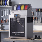 Titan Color 3D printer on a steel-and-wood workbench in an engineering workshop with calipers and a printed bracket