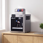 Titan Max Color 3D printer with its filament box on a light oak sideboard in a bright home office