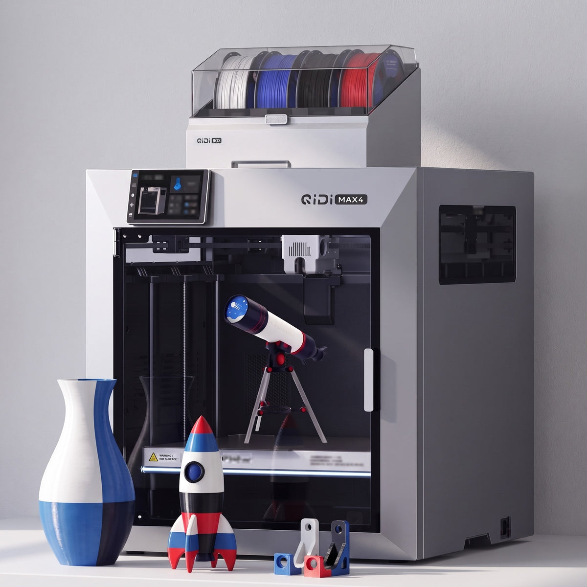 Titan Max Color 3D printer with a multicolor vase, toy rocket and printed brackets on a white table